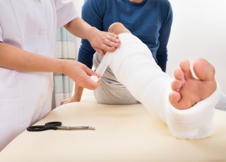 Doctor bandaging injured man (photo)